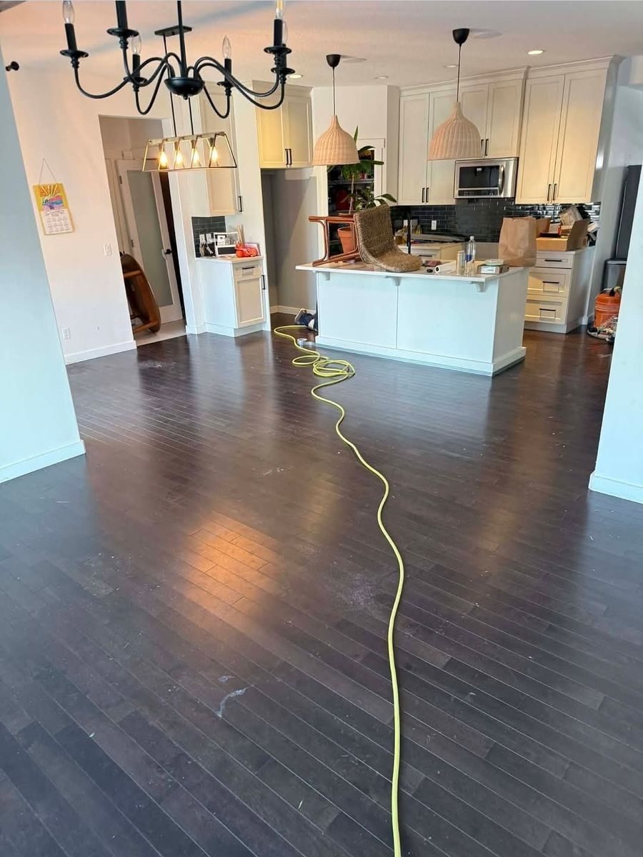 Maple hardwood floor with dark stain before color change, open-concept living room, Calgary Airdrie flooring